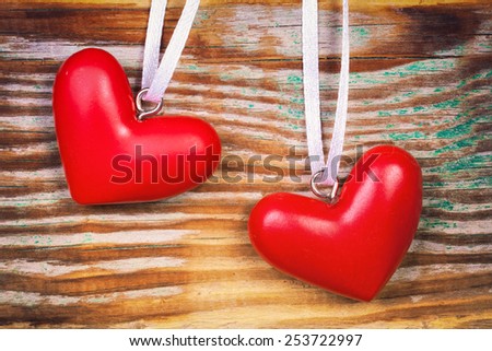 Two red hearts on grunge wooden background