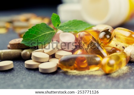 pills and multivitamins on a dark background, closeup Royalty-Free Stock Photo #253771126