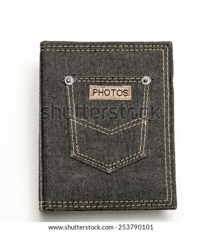 Denim pocket with a leather label 'PHOTOS' on photo album against a white background 