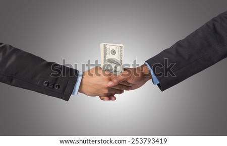 Hand shake between a businessman with dollar money on dark blue background