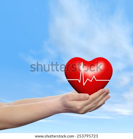 Concept conceptual 3D red human heart sign or symbol held in human man or woman hand, blue sky background, metaphor to health, care, medicine, protect, life, medical, pulse, healthcare cardiology