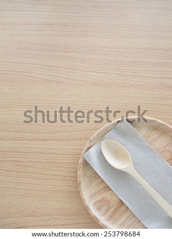 Wood plate with spoon on wooden table