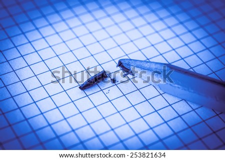 Broken pencil lying on a notepad. Image in cold toning
