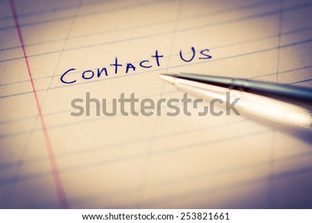 Contact us, sign in the notebook by pen. Image in cold toning