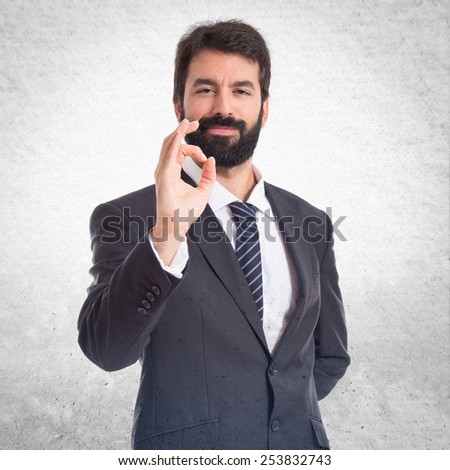 Businessman making Ok sign over textured background