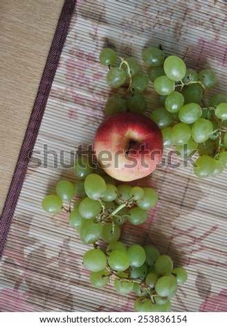 apple and grapes on wood napkin on table