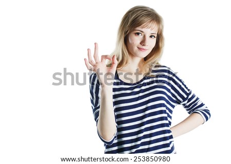 Closeup portrait of a smiling blonde woman showing ok gesture over white background