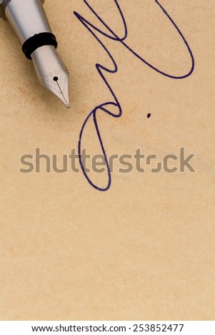 a signature and a fountain pen on yellow paper. symbolic photo for contract, testament and graphology