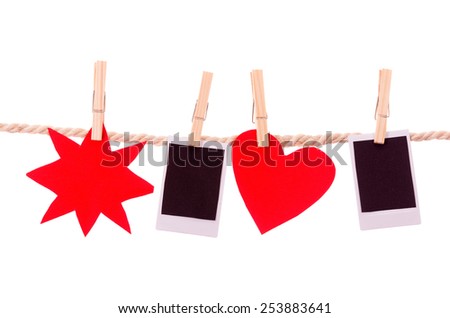 instant photographs and red shapes hanging on a rope clothesline isolated on white