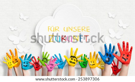 colorful painted hands in front of a decorated wall with the sentence "For our future" in German Royalty-Free Stock Photo #253897306
