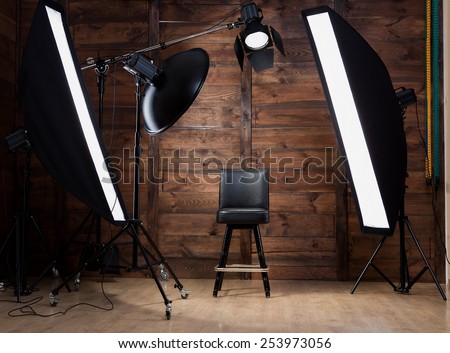 Lighting set up in photostudio with wooden background Royalty-Free Stock Photo #253973056