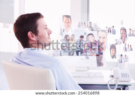 Smiling businessman sitting at his desk against handsome designer sit in his office