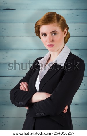Stylish redhead businesswoman in suit against wooden planks