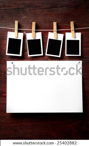 Photo paper attach to rope with clothes pins on wooden background