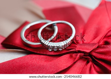 two wedding rings on red background.