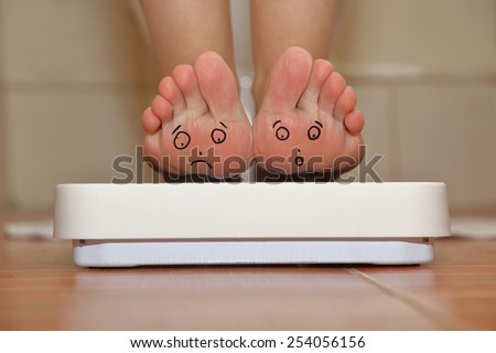 Feet on bathroom scale with hand drawn sad cute faces