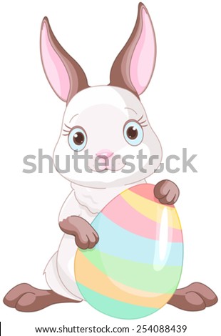 A cute Easter bunny standing near brightly colored egg