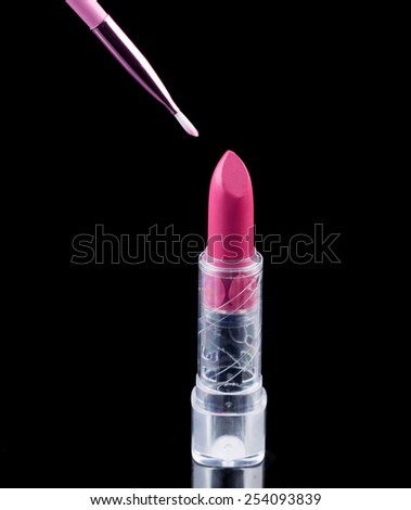 Tube of lipstick with a brush make-up on black 