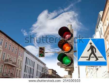 Traffic lights and pedestrian crossing sign in a city.