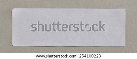 Stickers Label Close Up on Cardboard Background with Real Shadow. Top View of Adhesive Paper Tag. Copy Space for Text or Image