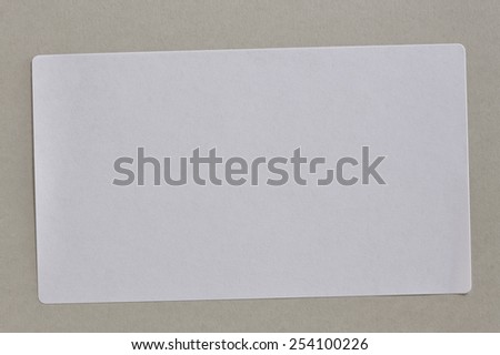 Stickers Label Close Up on Cardboard Background with Real Shadow. Top View of Adhesive Paper Tag. Copy Space for Text or Image