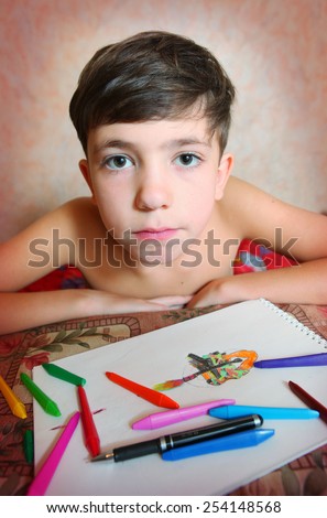 preteen handsome boy drawing with colored pencils and crayons