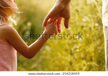 a parent holds the hand of a small child Royalty-Free Stock Photo #254218459