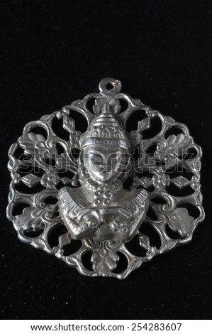 Silver Buddha Pendant Jewel over a Black Background