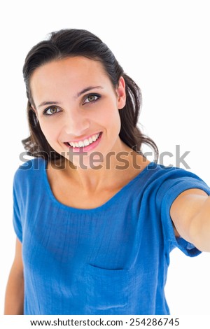 Pretty brunette taking a selfie on white background