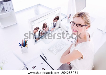 Female photo editor working on computer against glad businesswoman talking to her team Royalty-Free Stock Photo #254288281