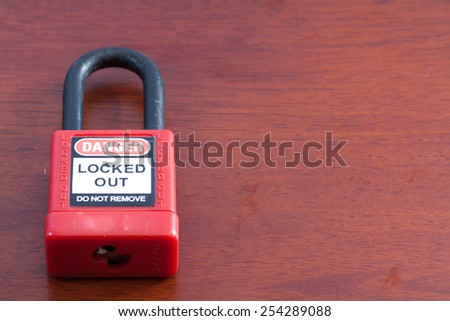 Lockout Padlock red color on wood background Royalty-Free Stock Photo #254289088