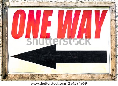 Vintage one way sign with black arrow showing the direction under red letters