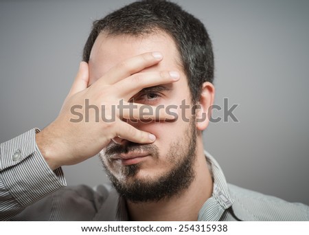 Portrait of a handsome man covering his eyes with hand 