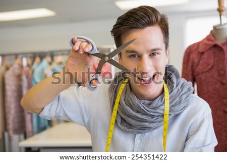 Smiling student holding pair of scissors at the college