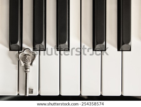 Piano keys and a silver key with G-clef musical symbol