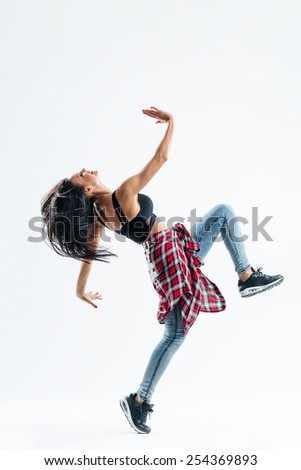 young beautiful dancer jumping on a studio background