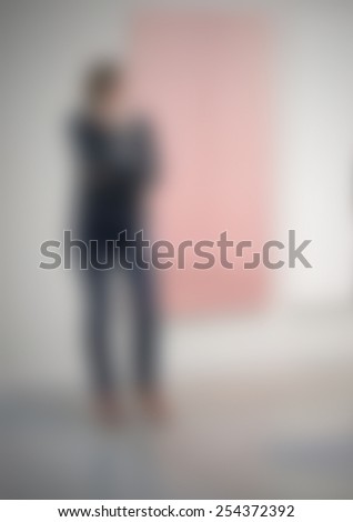 Woman at art gallery, generic background. Intentionally blurred editing post production.