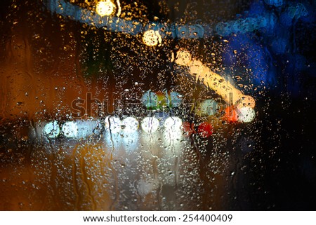 Wet the car window with the background of the night city lights
