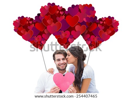 Pretty brunette giving boyfriend a kiss and her heart against valentines day