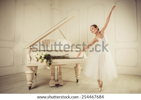  White piano stands in a large, bright interior, girl standing infront of it, she  She is dancing. on the piano keys are white roses.
