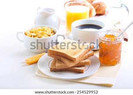 Breakfast: toasts, marmalade, cup of coffee and cornflakes Royalty-Free Stock Photo #254529952