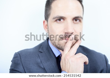 A beautiful business man standing against grey background on studio