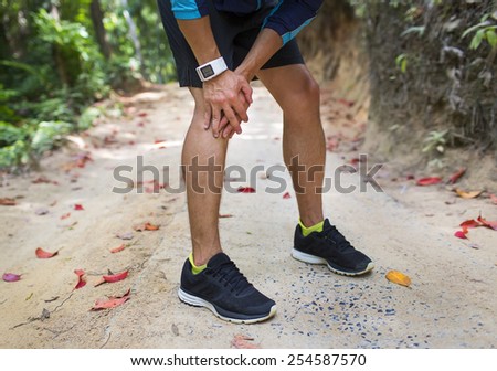 Runner holding sore leg, knee pain from running or exercising