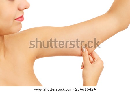 A picture of a frustrated woman showing her imperfect arms over white background