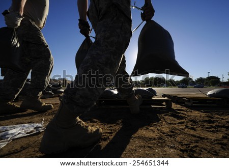National Guard soldiers move sandbags for flood relief Royalty-Free Stock Photo #254651344