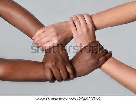 white Caucasian female hands and black African American holding together in world unity and racial love and understanding in tolerance races diversity cooperation concept isolated on grey background Royalty-Free Stock Photo #254653765