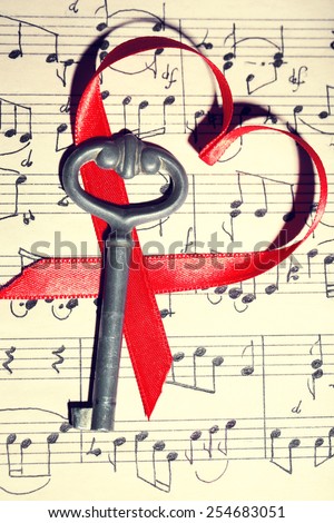 Retro key with heart on music book background