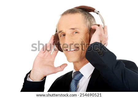 Portrait of businessman with headphones listening to music.