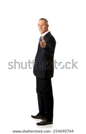Smiling mature businessman gesturing ok sign.
