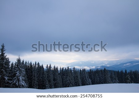 Black clouds hung over the beautiful mountain panorama. Winter landscape.